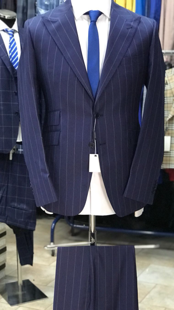 Navy pinstripe 2 button super 150 Cerruti wool suit with wide 5 inch hand stitched peak lapel, slanted ticket pocket, flat front pant, double vent. Slim fit. Available in sizes: 38-50 Reg/Long