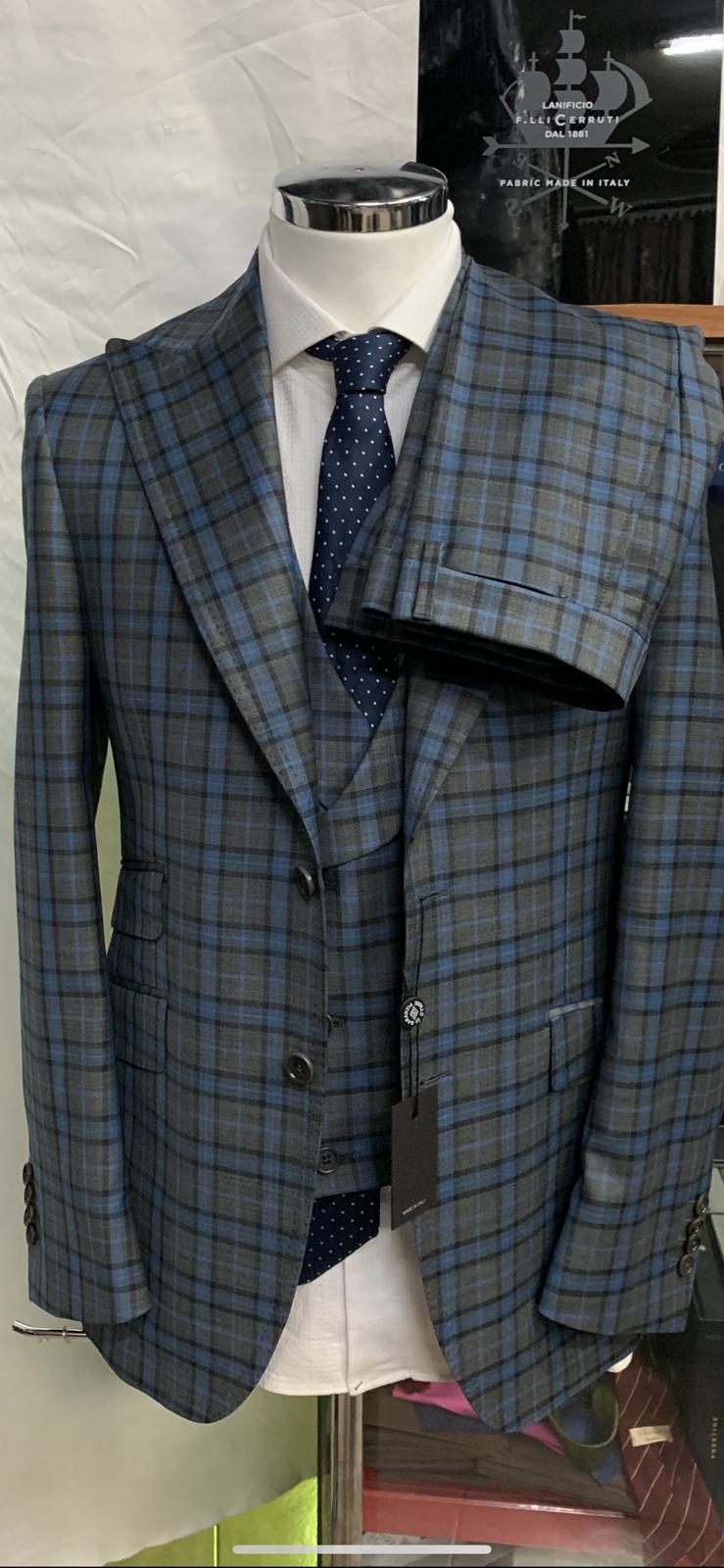 Grey/blue plaid super 150 Cerruti 3 piece wool suit with double breasted vest. Double 5 inch Tom Ford peak lapel, double vents, ticket pocket. Available in sizes: 36 to 52 regular