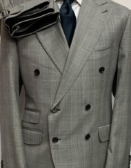 Grey prince of Wales plaid double breasted super 150 Cerruti wool suit. Wide 5 inch Tom Ford peak lapel. Ticket pocket, double vents, flat front pant with side buckle . Available in size 38/40/42/44/46/48/50 regular and Long.